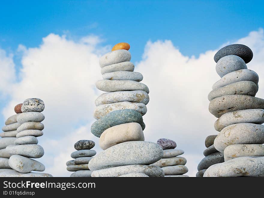 Piles from a sea pebble against the summer sky. Piles from a sea pebble against the summer sky