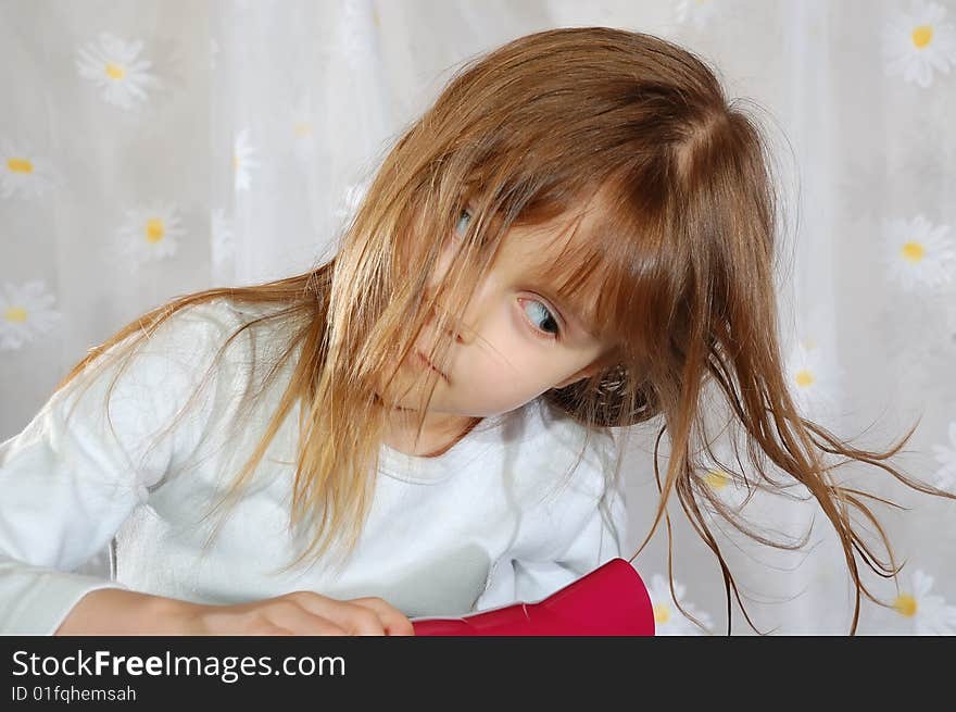 Portrait of a little girl drying her hair with a hairdryer. Portrait of a little girl drying her hair with a hairdryer