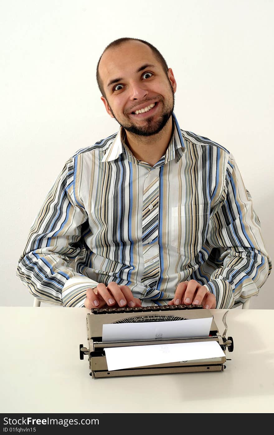 Man typing a document on an antique typewriter in an office. Man typing a document on an antique typewriter in an office