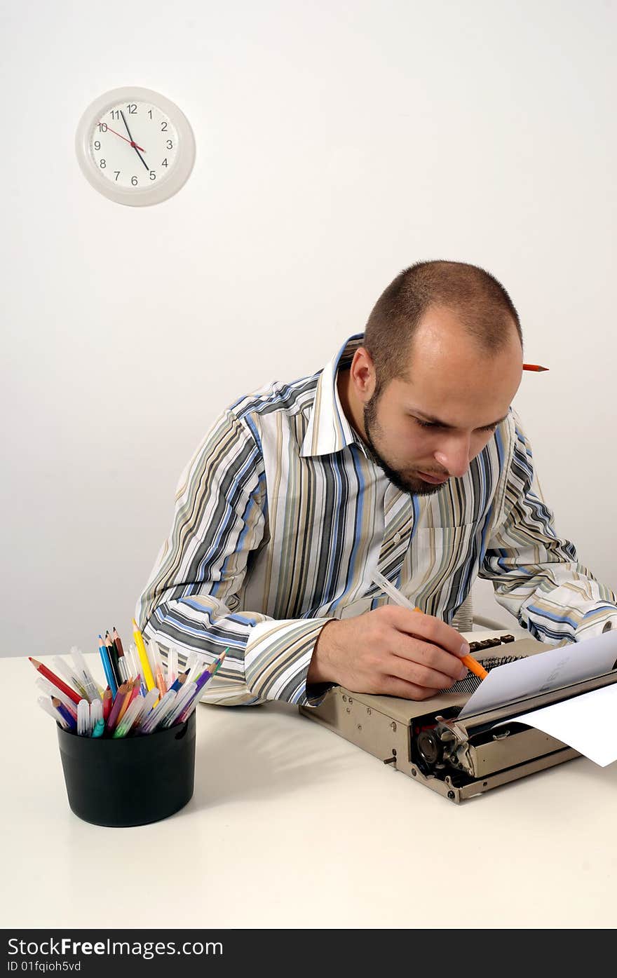 Man typing a document on an antique typewriter in an office. Man typing a document on an antique typewriter in an office