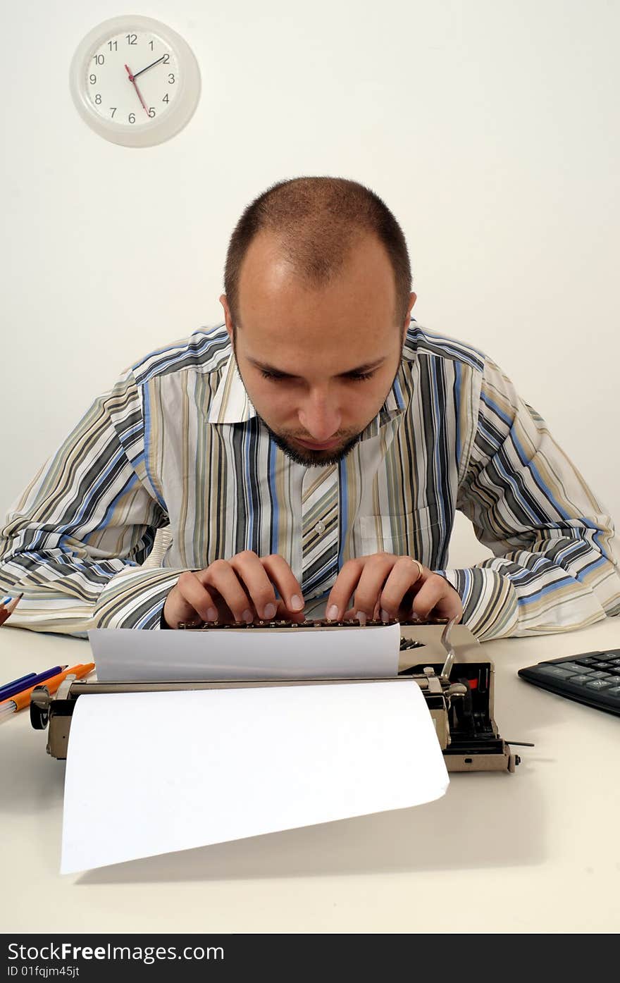 Man typing a document on an antique typewriter in an office. Man typing a document on an antique typewriter in an office