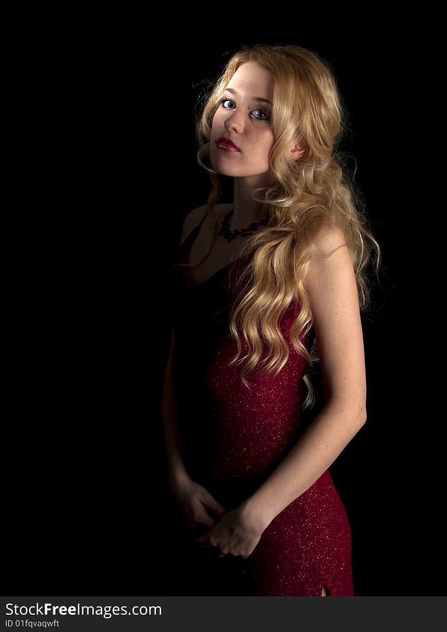 Beautiful blonde young lady in red dress on black background. Beautiful blonde young lady in red dress on black background