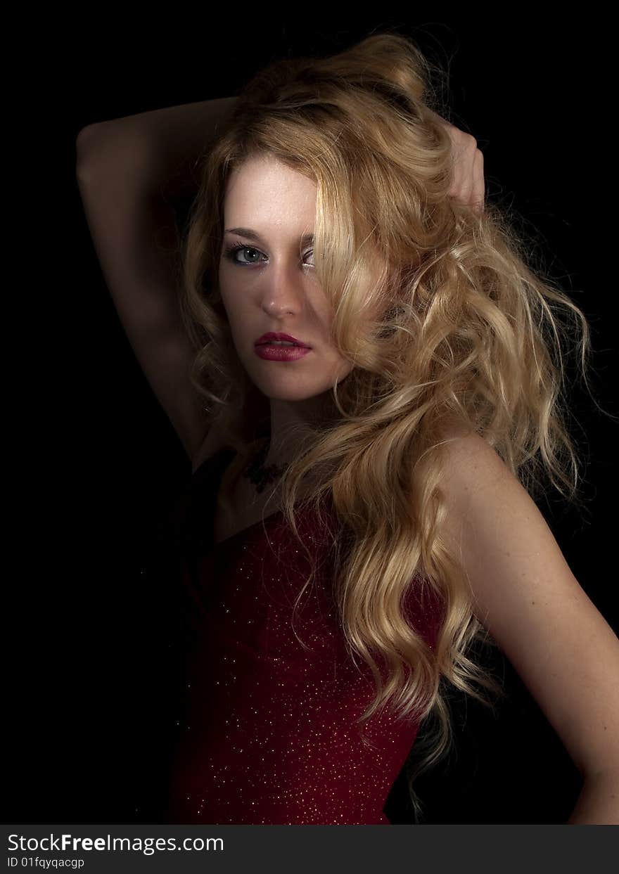 Beautiful blonde young lady in red dress on black background. Beautiful blonde young lady in red dress on black background