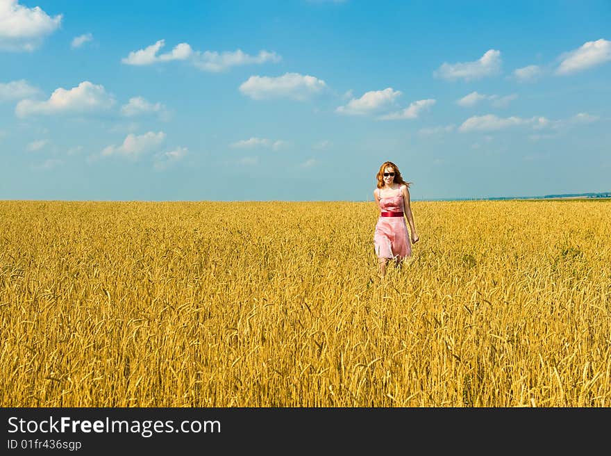 Happy girl walks over the field.