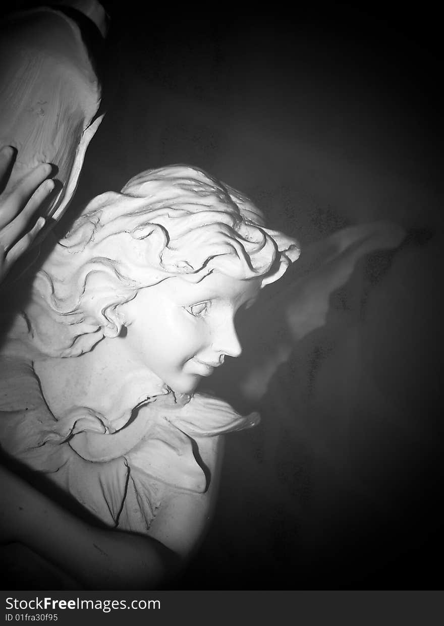 Clay garden angel outside at midnight