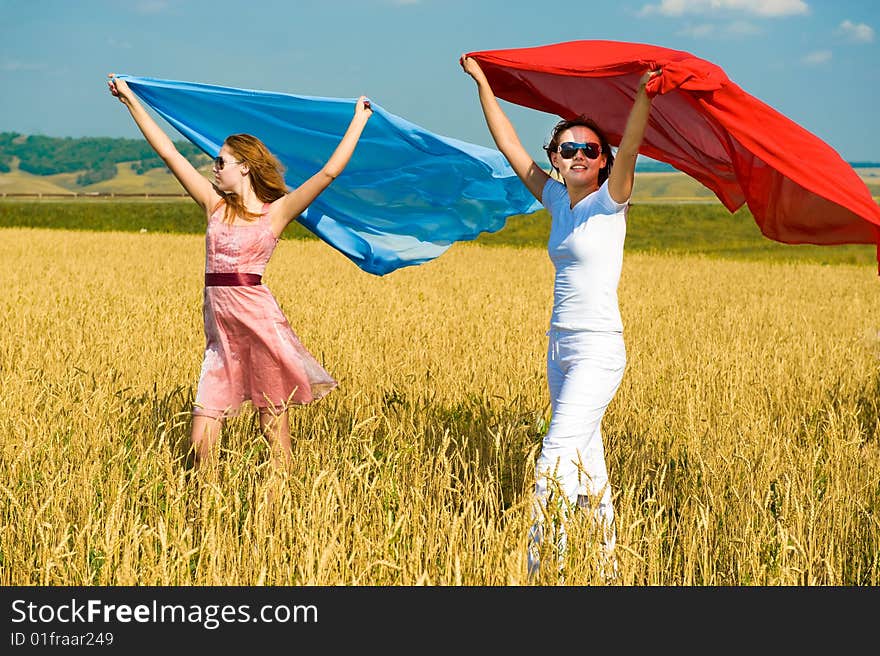 Two young beautiful woman running on the field