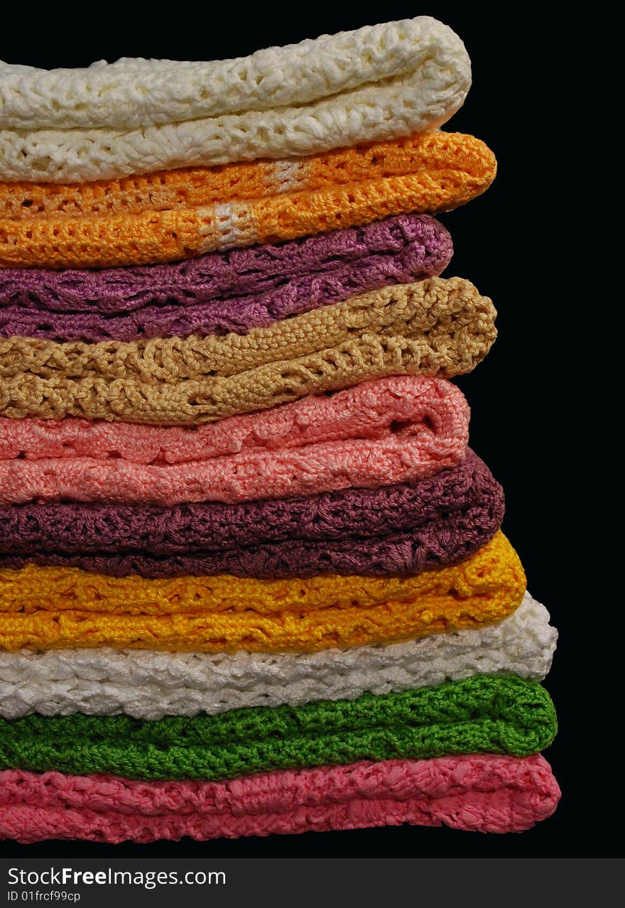 Stack of colored jackets isolated on black