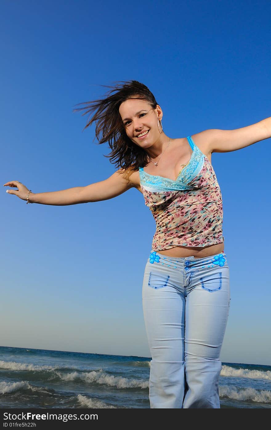 Portrait of young fashion woman enjoying the summer breeze by the ocean. Portrait of young fashion woman enjoying the summer breeze by the ocean