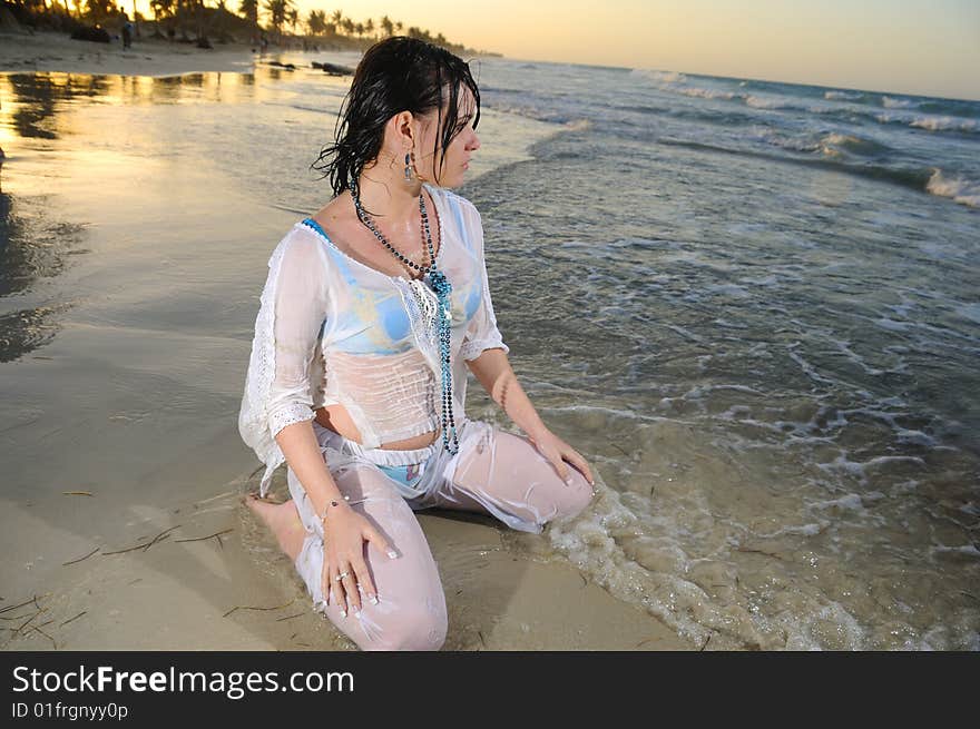 Portrait of young woman sitting and relaxing on tropical beach. Portrait of young woman sitting and relaxing on tropical beach