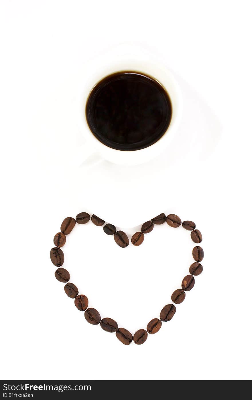 Heart made of coffee beans and a cup of coffee isolated at the white background