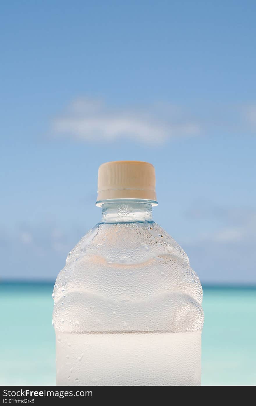 Cold bottle of water on beach