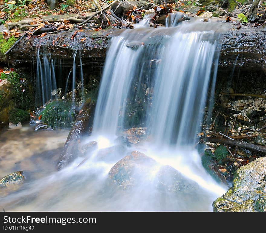 Beautiful autumn waterfall between rocks