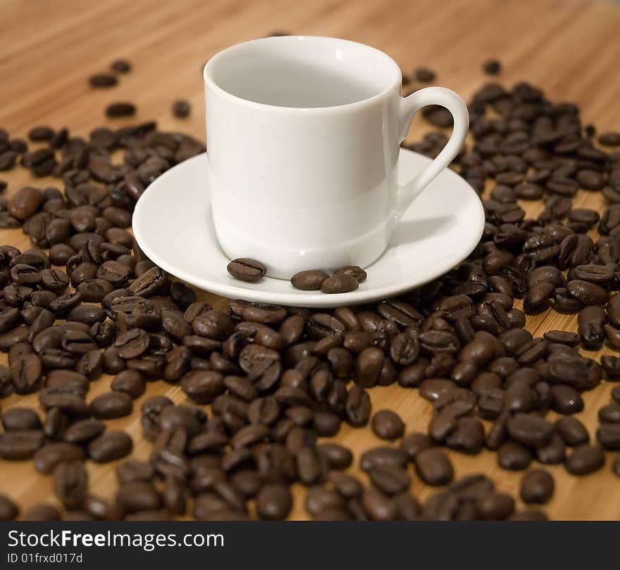 Espresso Coffee Beans with cup and saucer on wood tabletop