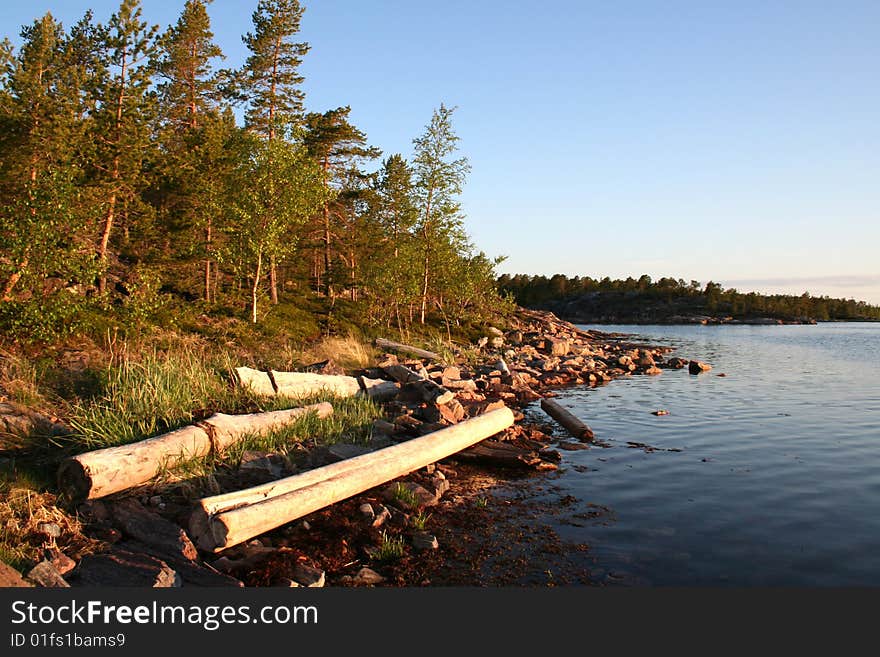 Summer sunrise with forest, water and rocks