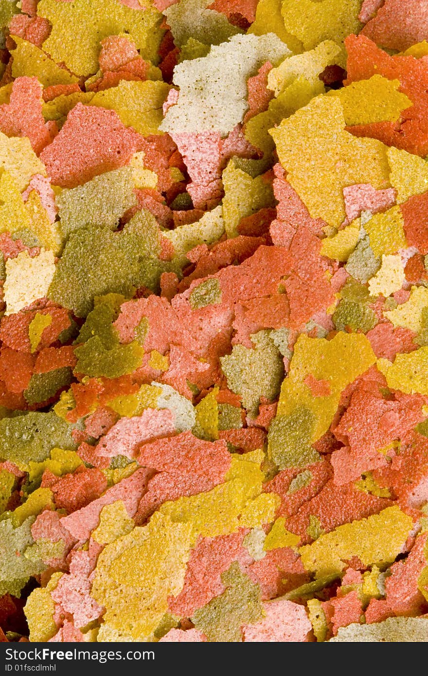 A close-up of a lot of dry goldfish food