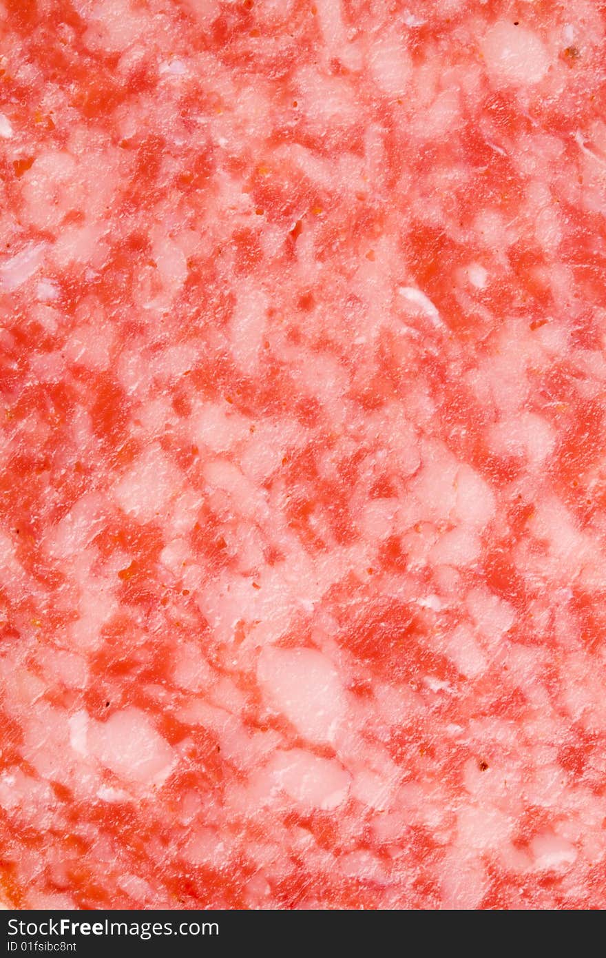 A close-up of the texture of a slice of salami. A close-up of the texture of a slice of salami