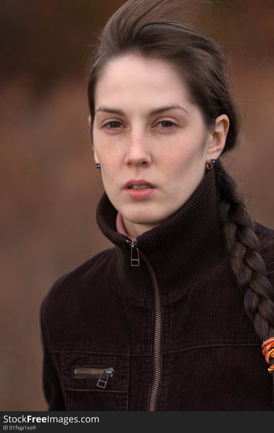 Portrait of serious pretty girl on blurry brown background - shallow DOF