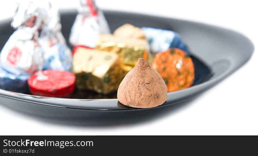 Assorted chocolate candy on black plate