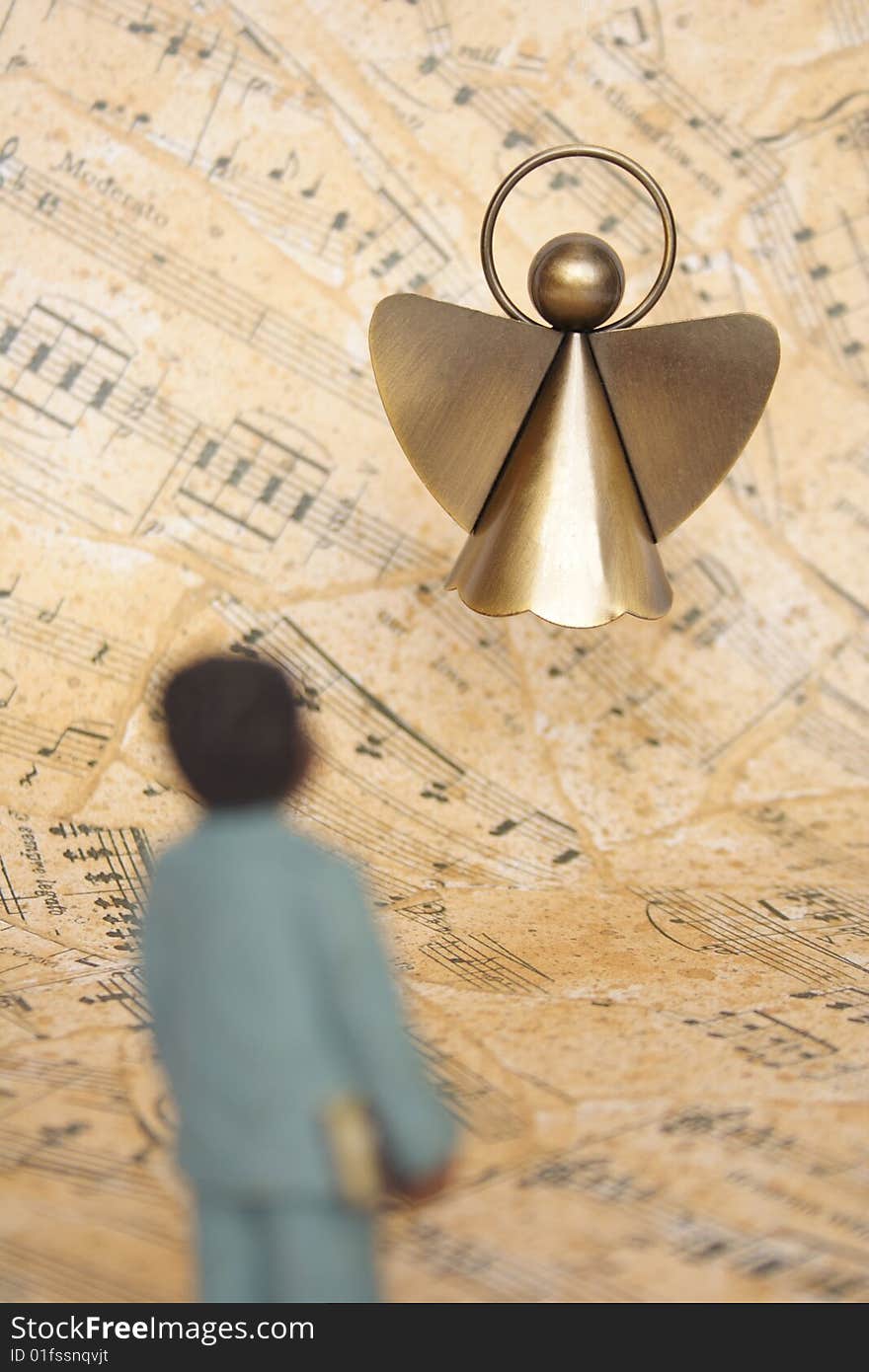 Boy and angel with a music sheet as background. Boy and angel with a music sheet as background