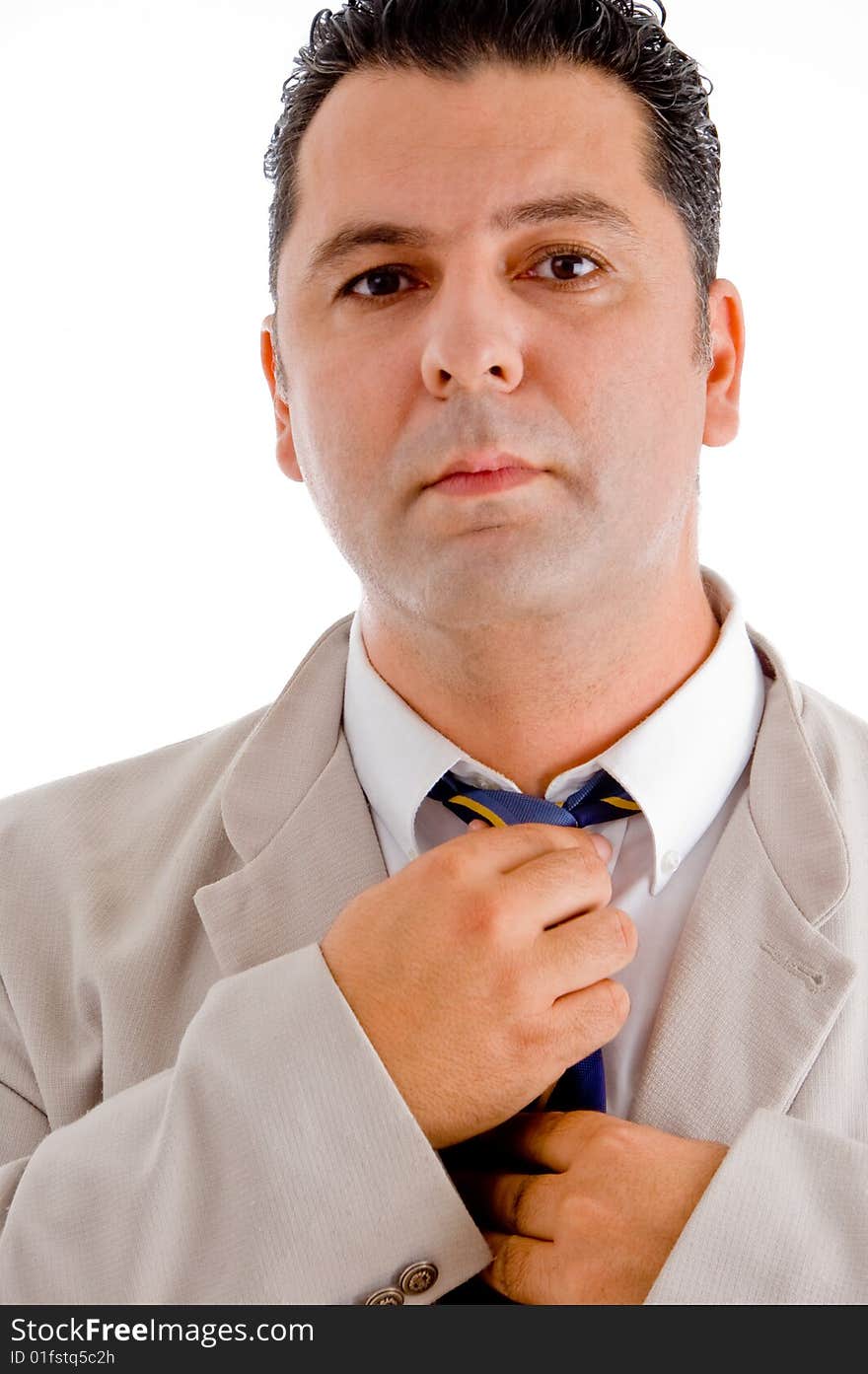 Flourishing businessman tying his tie and looking to camera