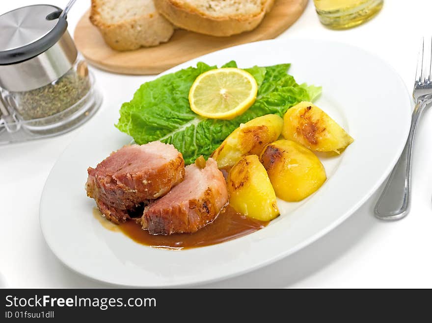 Roasted Slices Of Pork With Lettuce And Fried Pota