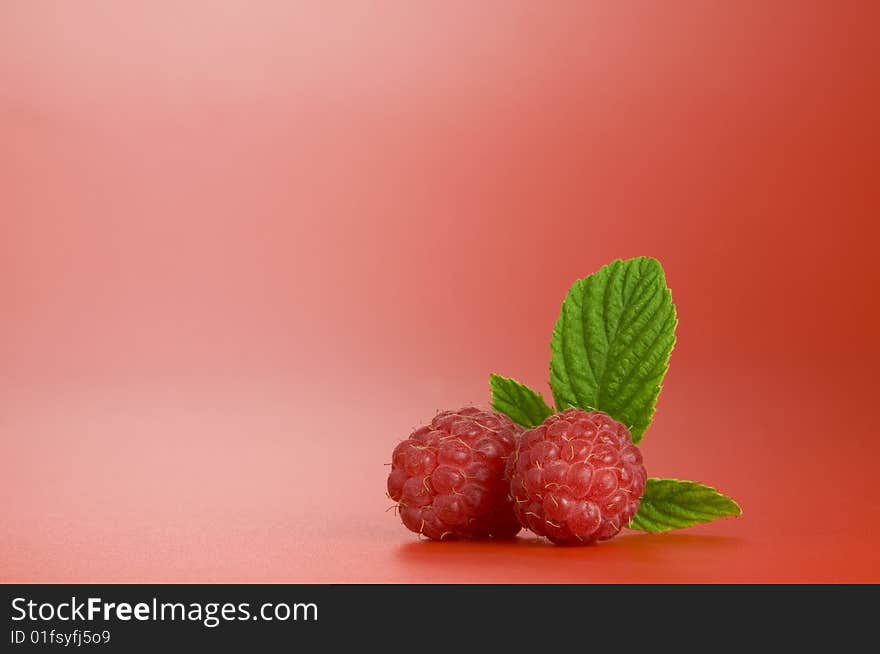 Close up view of nice fresh red raspberry on red back. Close up view of nice fresh red raspberry on red back