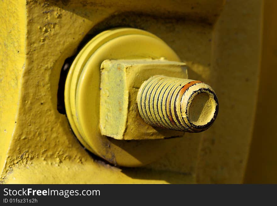 Close-up of large nut and bolt painted bright yellow. Close-up of large nut and bolt painted bright yellow.