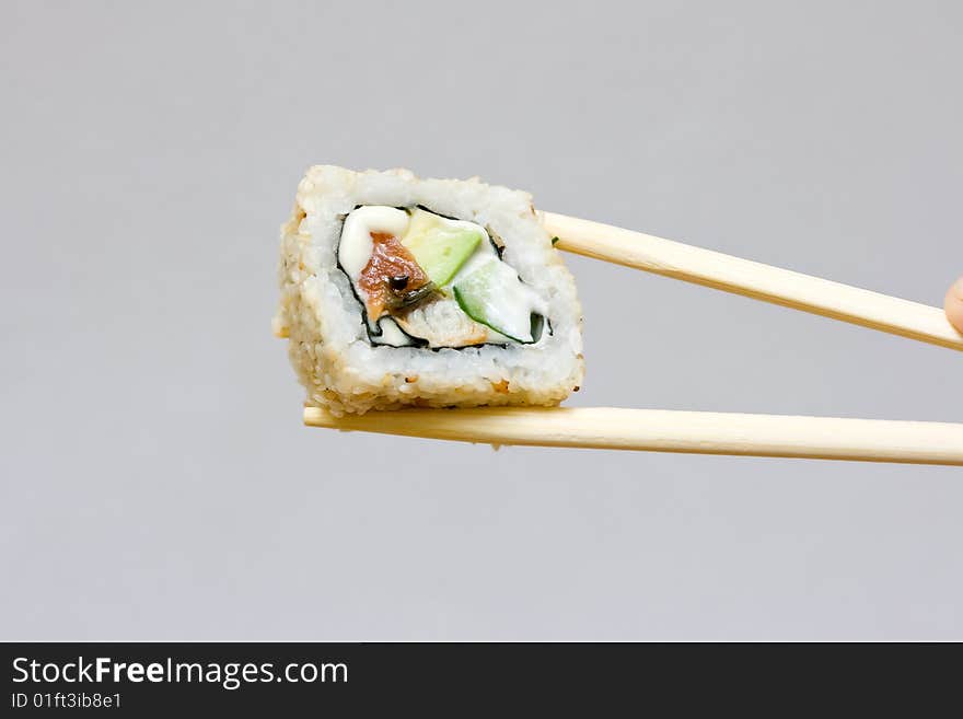 Sushi and chopsticks on the neutral background