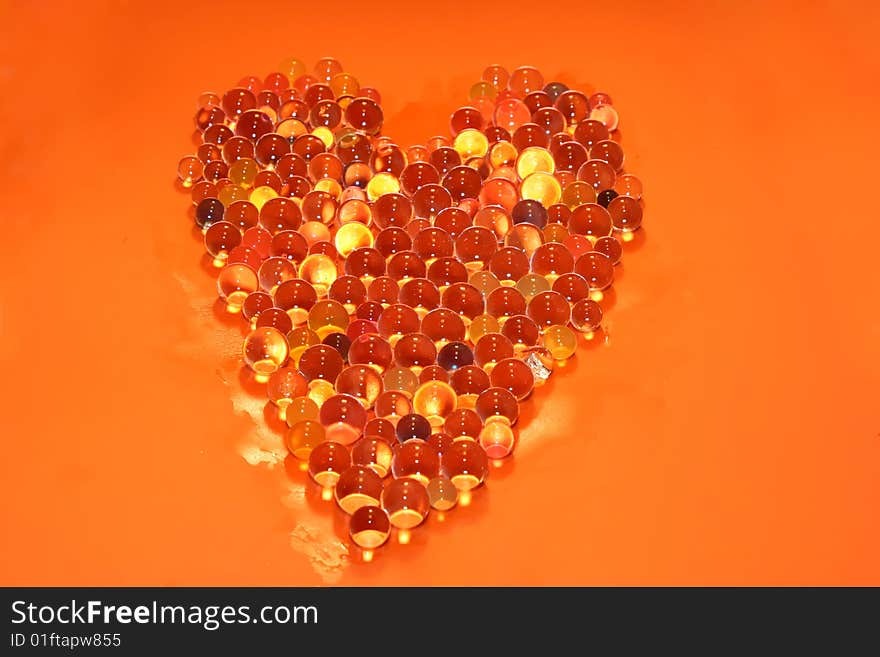 Water bubbles making a heart in a orange background. Water bubbles making a heart in a orange background