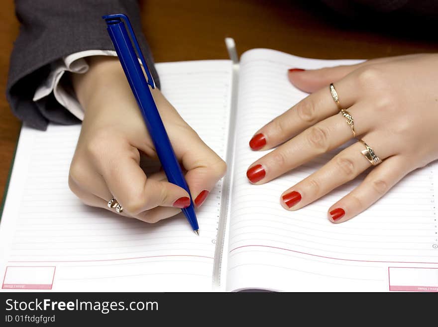 Female hands write on the organizer. Female hands write on the organizer