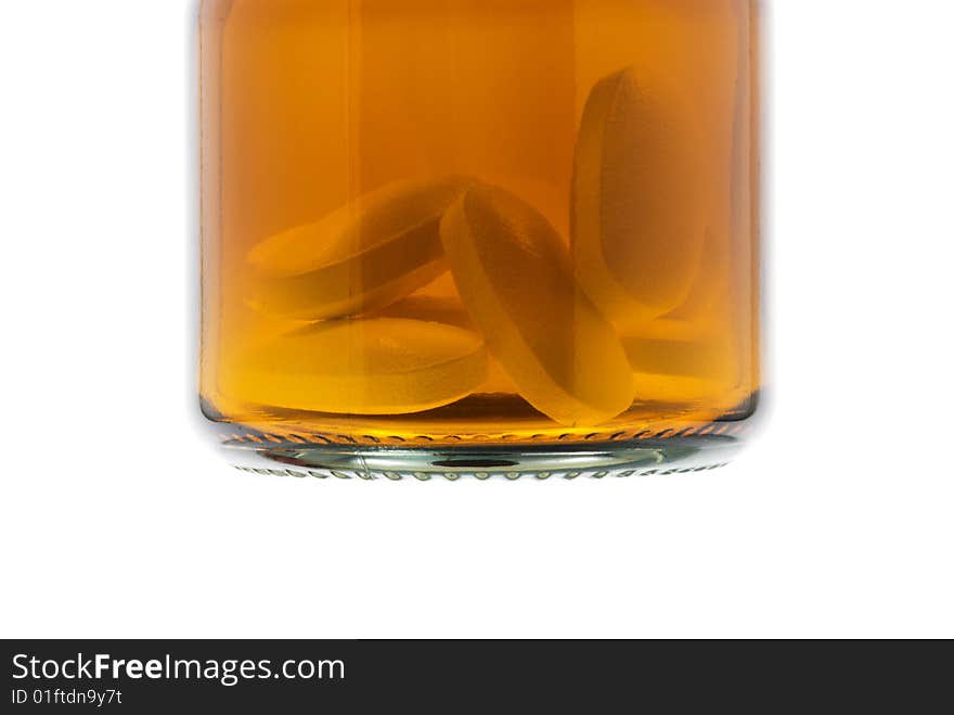 Transparent bottle with pills over white background