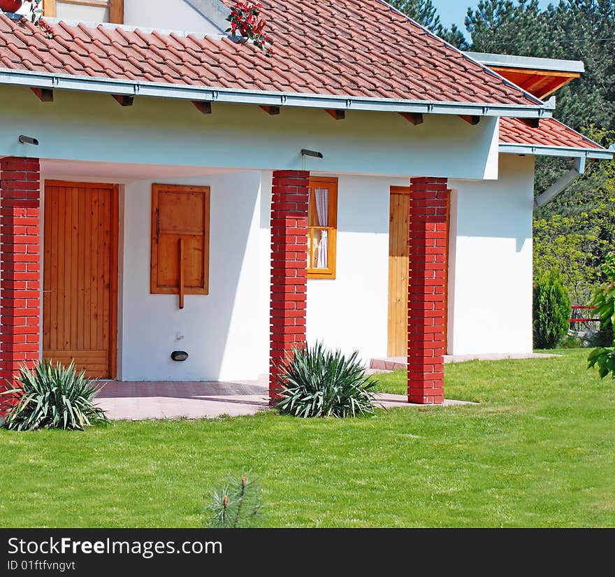 Fragment of small house tiled roof and garden. Fragment of small house tiled roof and garden