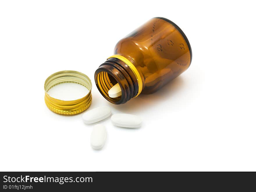 Transparent bottle with pills over white background