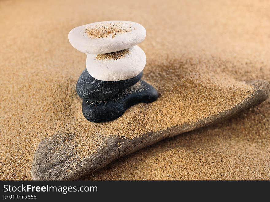 White and black sea pebble in a pile on sand