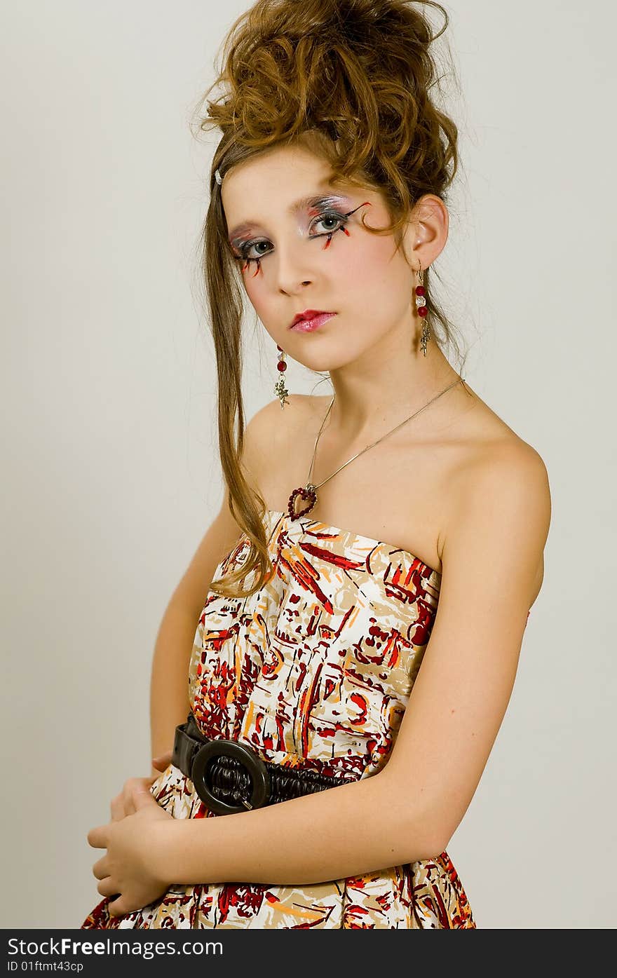 Closeup of young fashion girl with special eye makeup wearing colored top and black belt