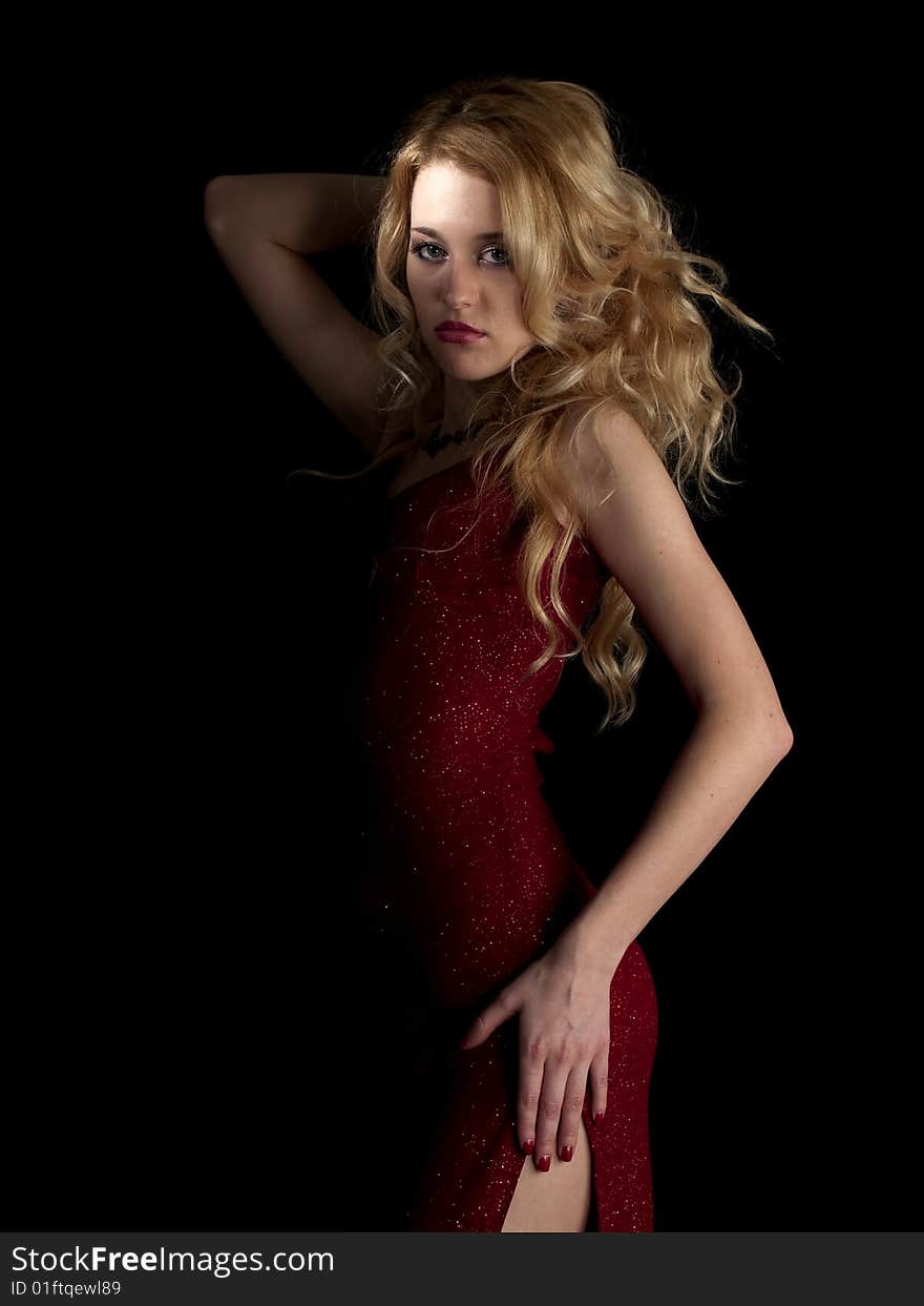 Beautiful blonde young lady in red dress on black background. Beautiful blonde young lady in red dress on black background