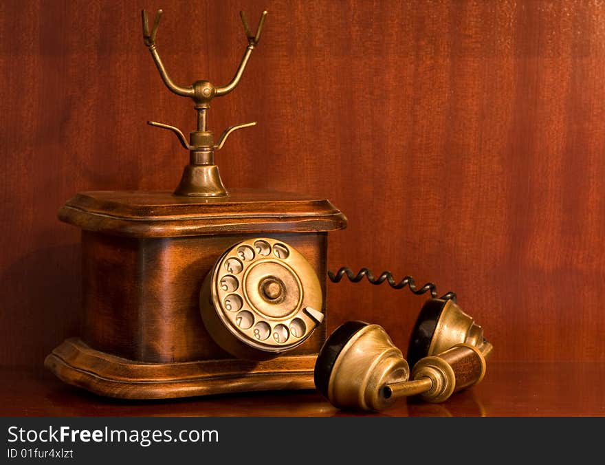 An antique telephone with the receiver left on hold. An antique telephone with the receiver left on hold