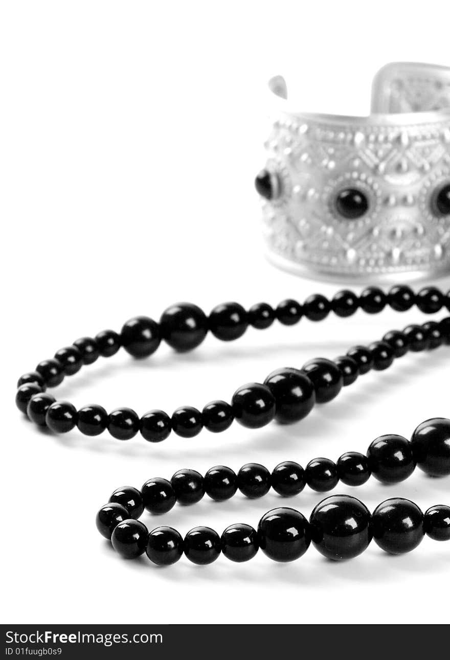 Bracelet and black necklace closeup on a white background