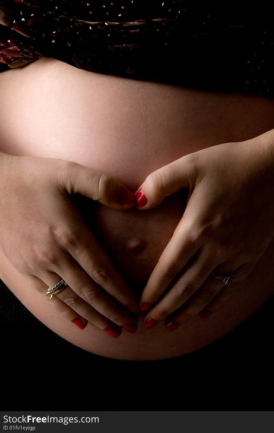 Side view of pregnant woman holding her tummy on an isolated background