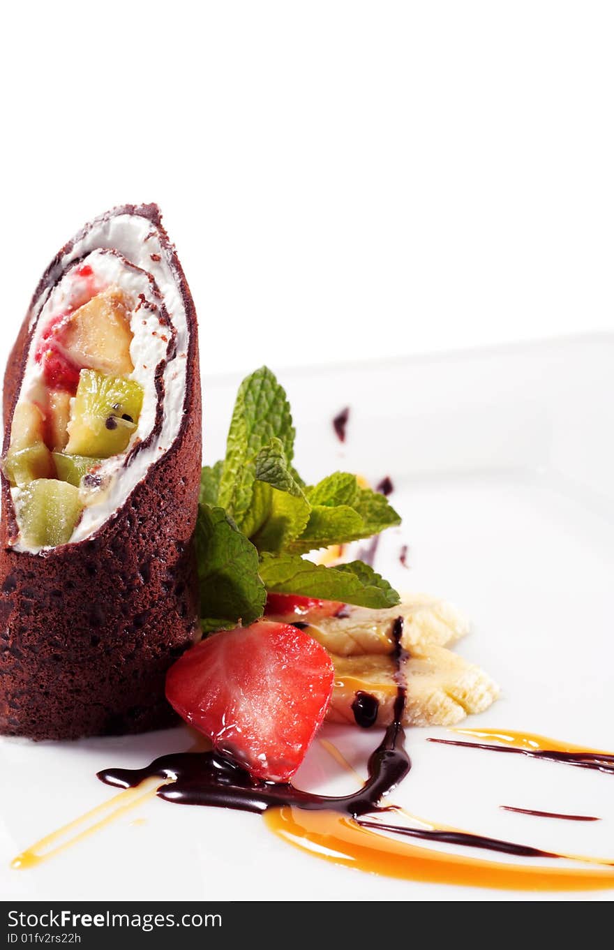 Chocolate Pancakes with Fruit Wrap. Served with Chocolate and Caramel Sauce. Isolated on White Background