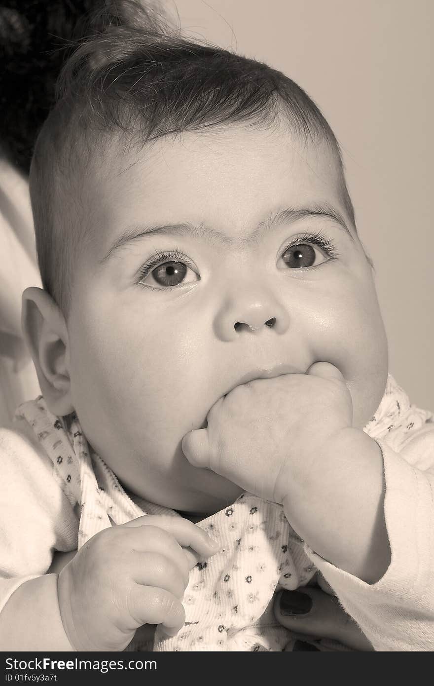 A baby with her hand in her mouth