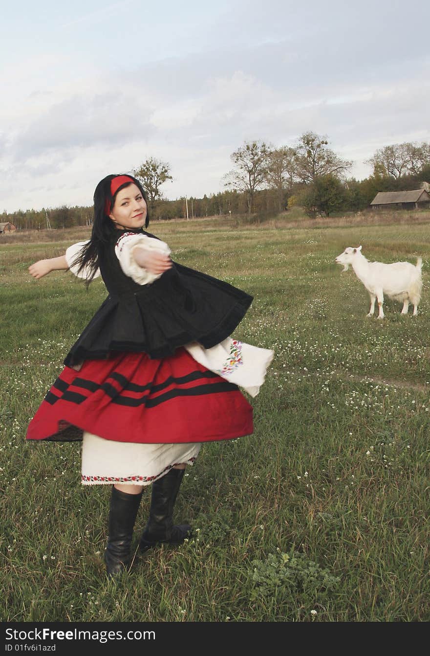 Village girl in Ukrainian clothes with goat