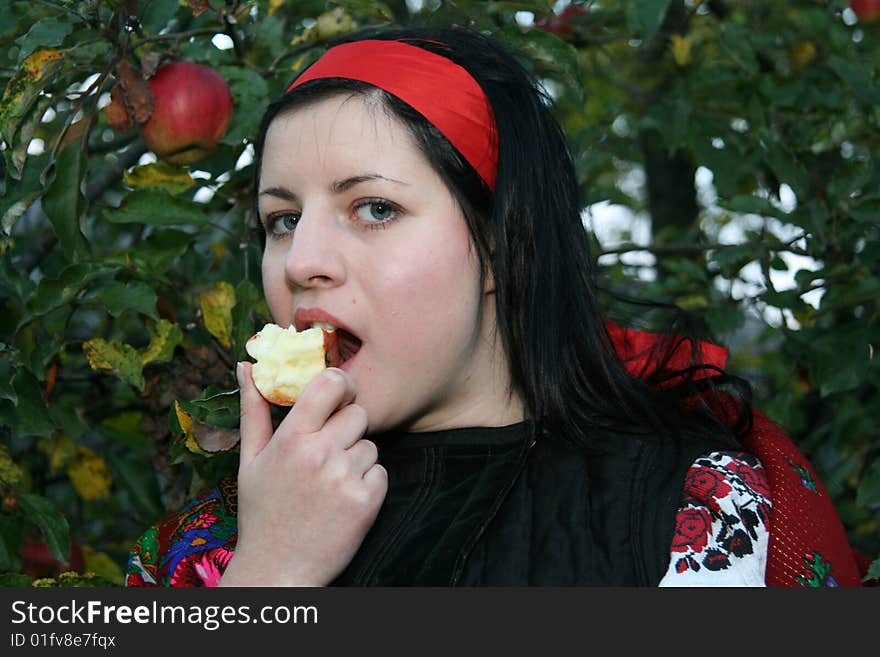 Village girl eating an aple in Ukrainian clothes eating an apple