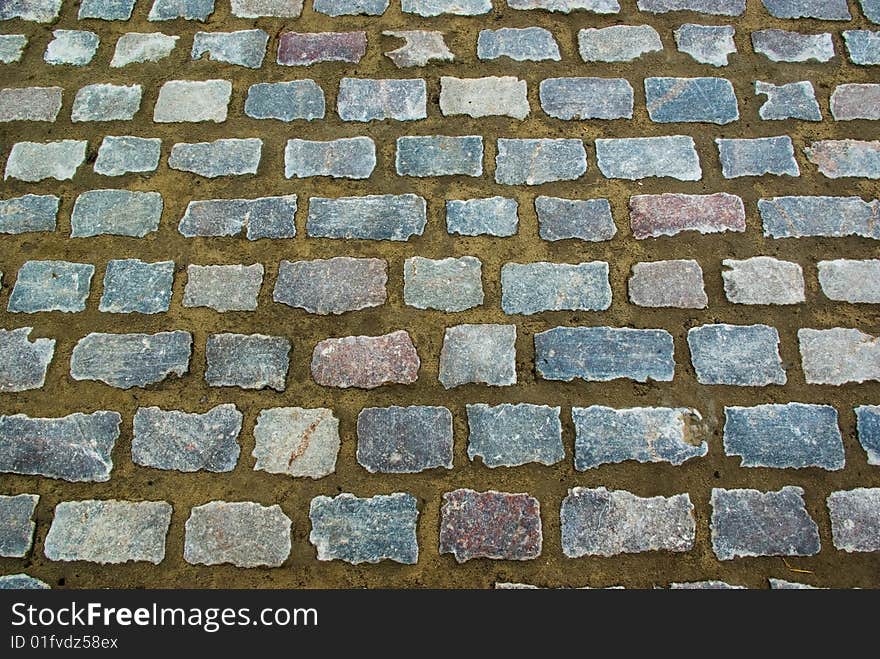 Street background made of grey granite stones