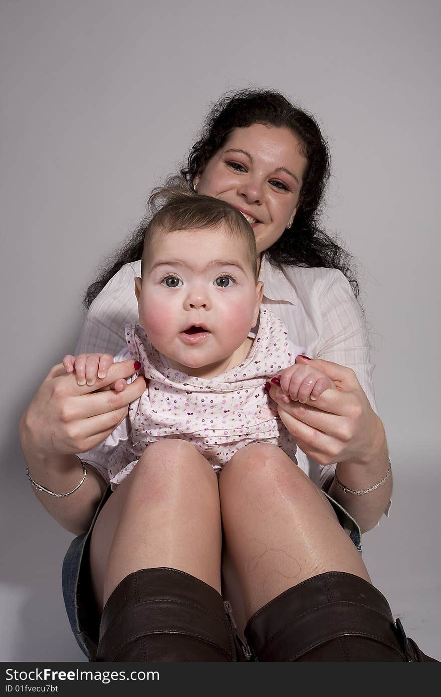 Baby leaning on legs of mom