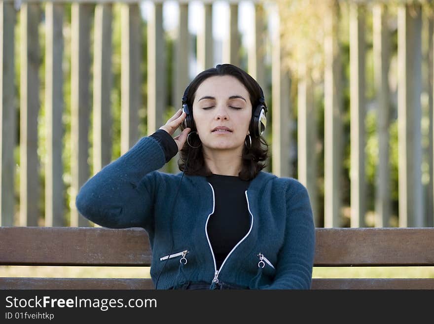 Young woman listens to music in park. Young woman listens to music in park