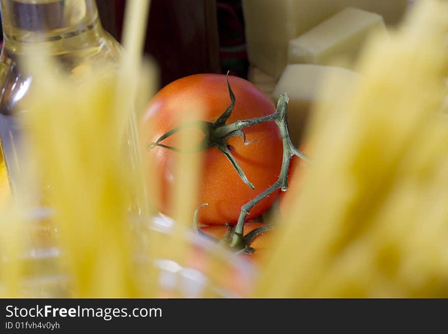 Tomato behind raw spaghetti in glass container