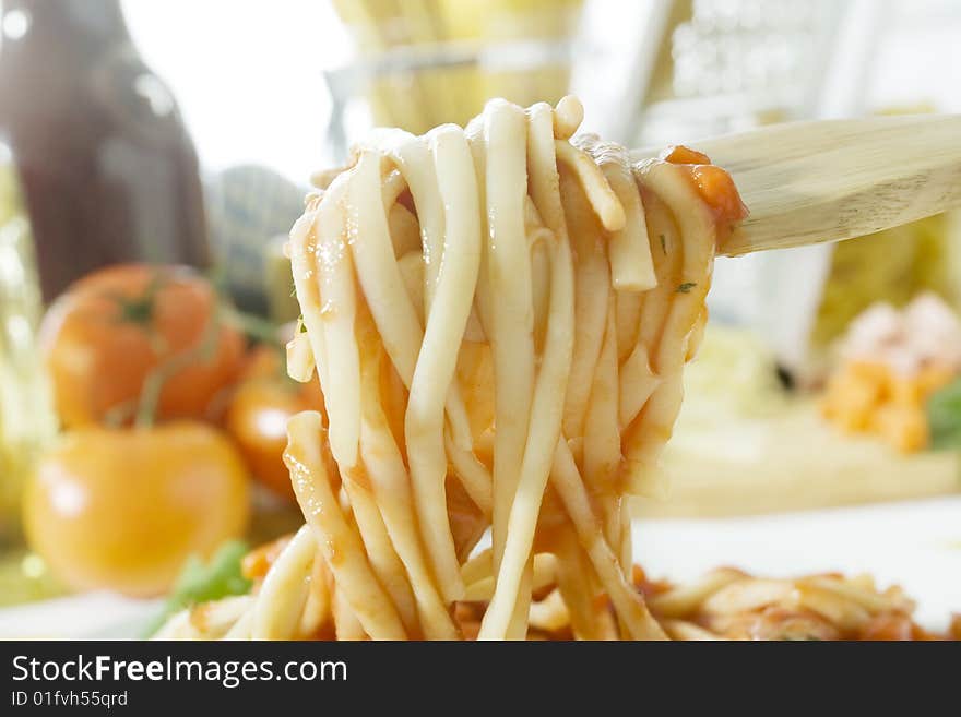 Close up shot wooden fork with freshly cooked spaghetti. Close up shot wooden fork with freshly cooked spaghetti