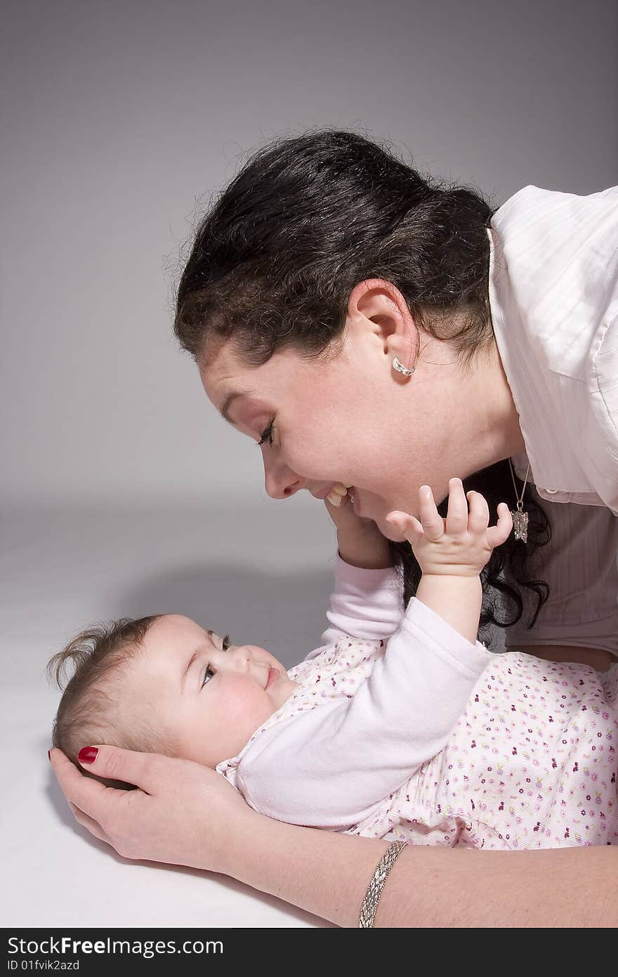 A baby that is reaching for her mother. A baby that is reaching for her mother