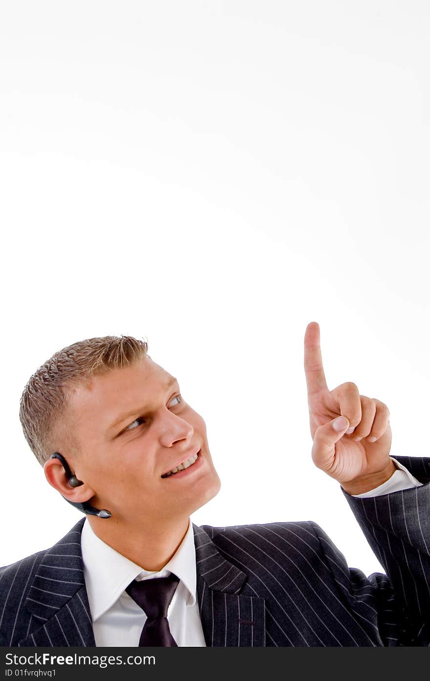 Young businessman pointing upwards against white background